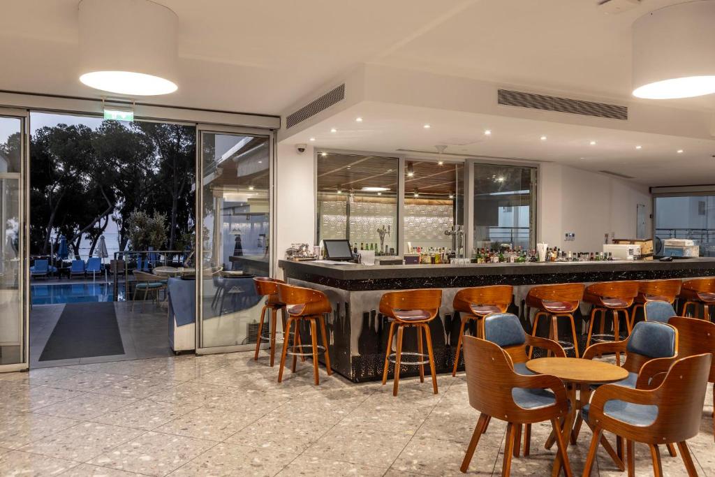 a bar in a restaurant with chairs and tables at Park Beach Hotel in Limassol