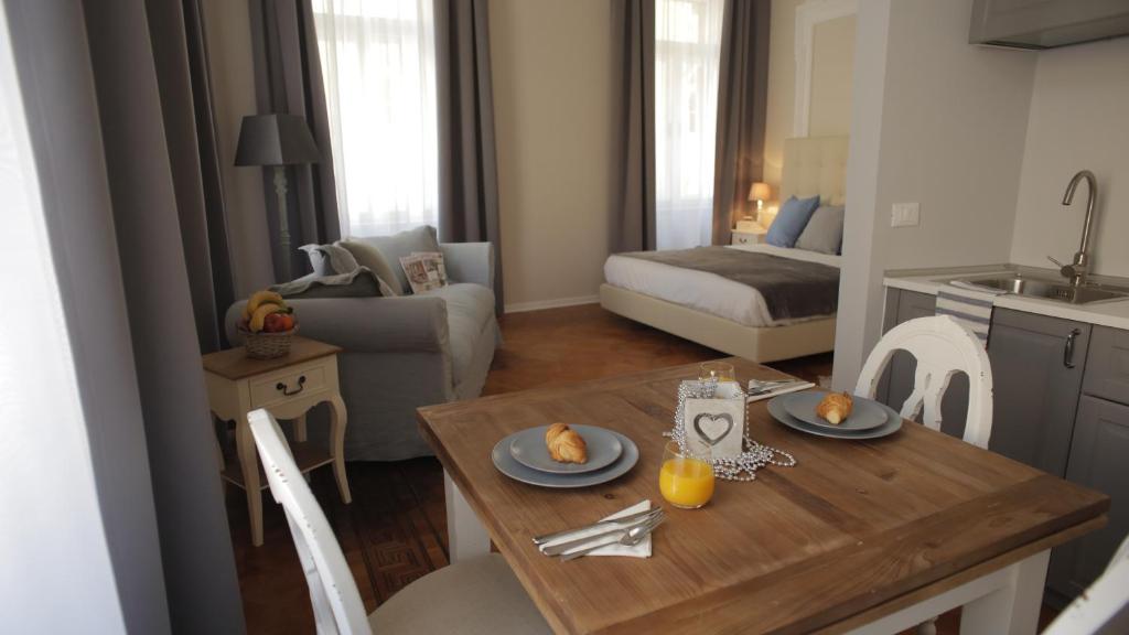 cocina y sala de estar con mesa de madera y sillas en Ponterosso Suite, en Trieste