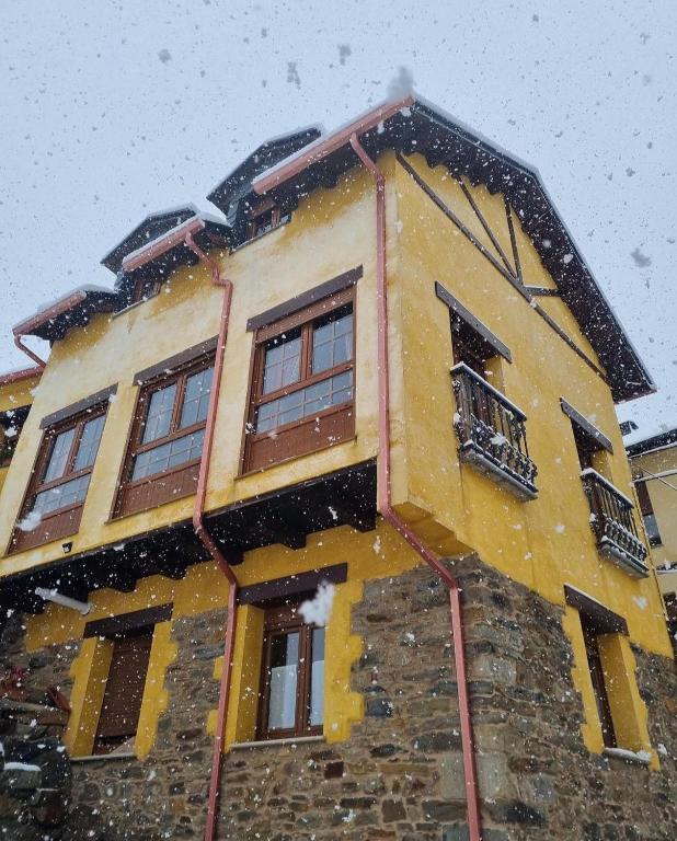 a house with snow falling on the side of it at Casa Begoña in Igüeña