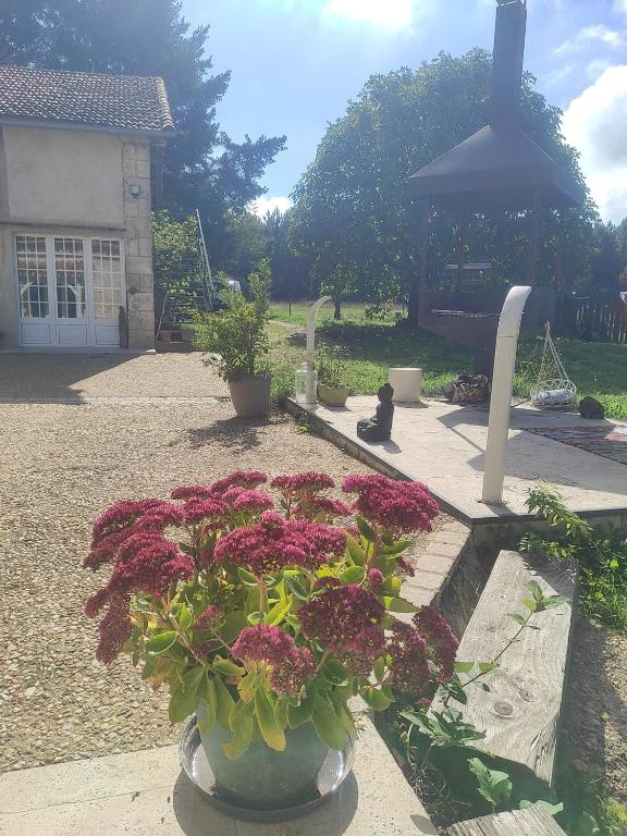 un vase rempli de fleurs devant une maison dans l'établissement Les jardins de Shambhala, à Montrem