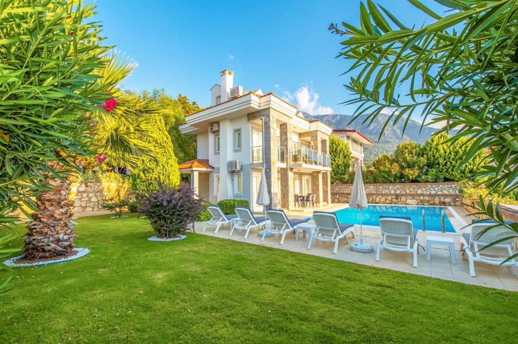 una casa con piscina y sillas en un patio en Golden Heights 15, en Ölüdeniz
