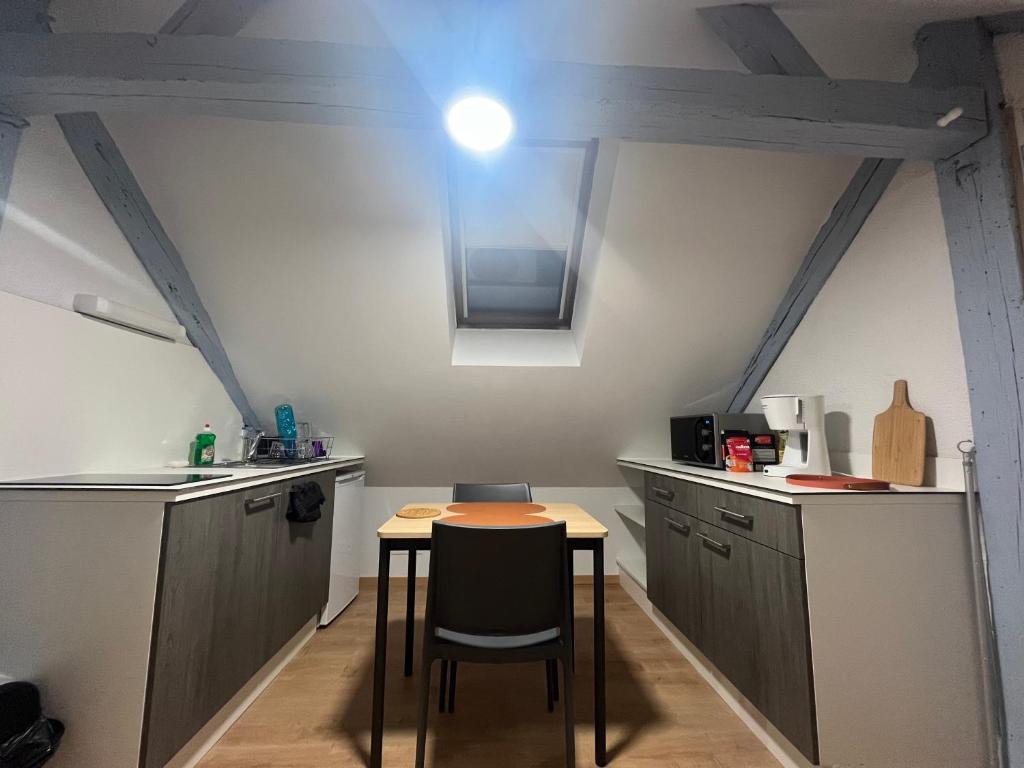 une cuisine avec une table et des chaises dans une pièce dans l'établissement Le Saint-Georges, à Angers