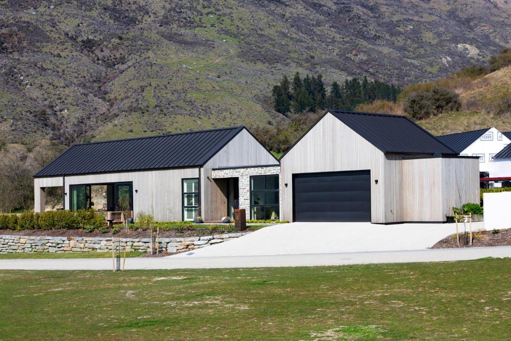 a white house with a black garage at Beautiful Haven - Stunning Luxury Home - Queenstown - NEW!! in Queenstown