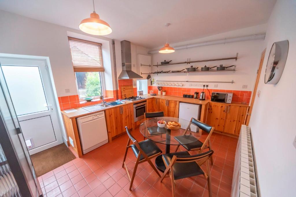 a kitchen with a glass table and chairs in it at Pass the Keys Spacious Garden Home in New Mills - Pet Friendly in New Mills