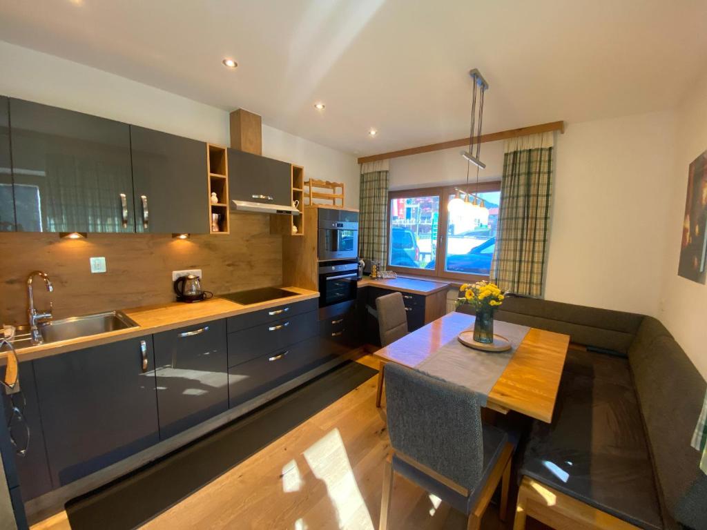 een keuken met een wastafel en een tafel. bij GondelApart Ski in Ski out in Jochberg