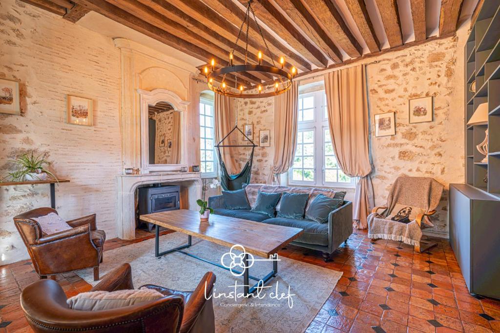 a living room with a couch and a table at Manoir d'Exception - 20 Personnes - Piscine, Baby-Foot & Tapis de Course in Coulaines