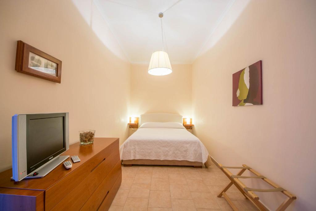 ナポリにあるLa Residenzaのベッドルーム(ベッド1台、薄型テレビ付)