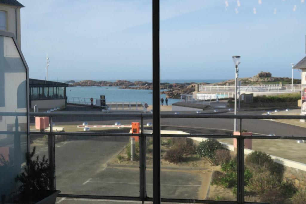 - une vue depuis la fenêtre d'une rue et une étendue d'eau dans l'établissement Appartement avec WIFI VUE SUR MER plage du Coz-Pors à TREGASTEL - Réf 609, à Trégastel