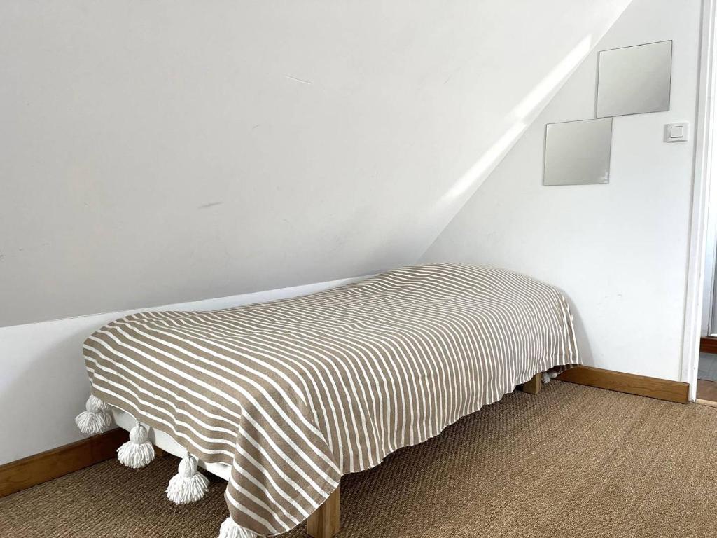 Cette chambre comprend un lit avec une couverture rayée. dans l'établissement Maison de charme avec terrasse à PERROS-GUIREC - Réf 550, à Perros-Guirec