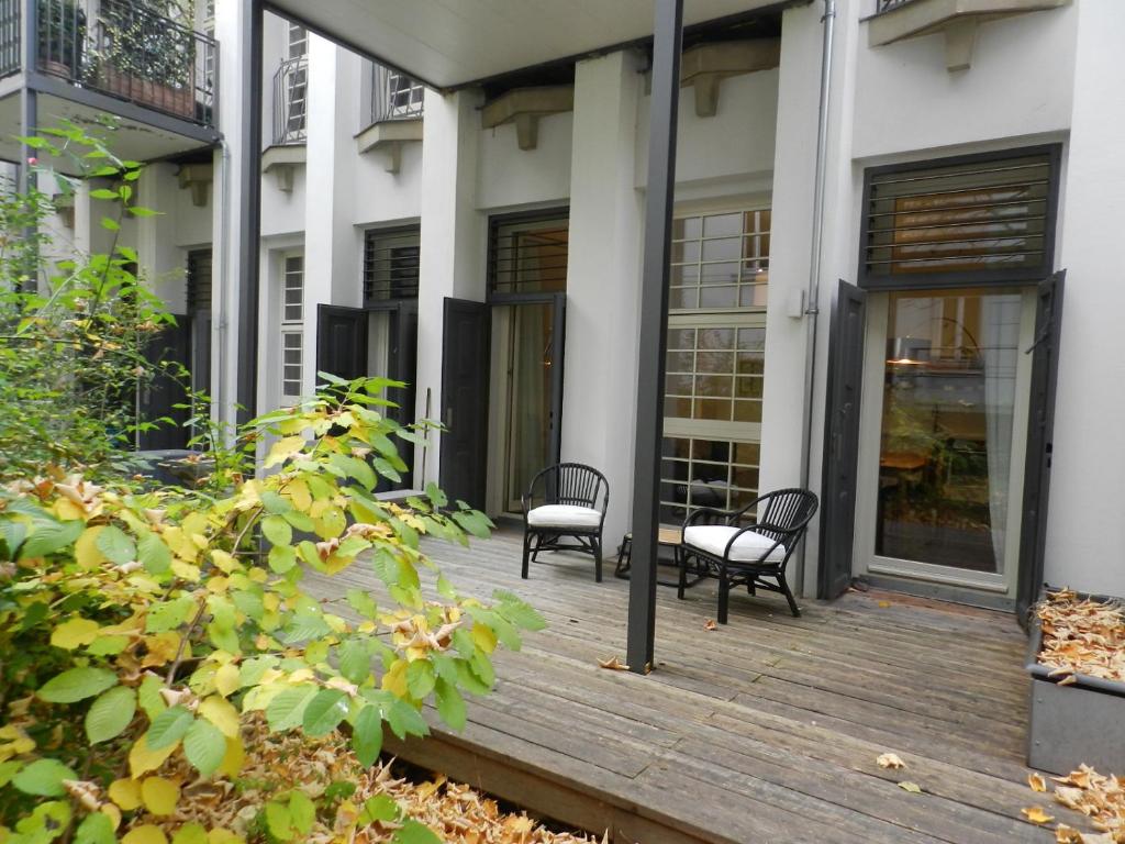 萊比錫的住宿－萊比錫裝飾藝術公寓，大楼前的木甲板上摆放了两把椅子