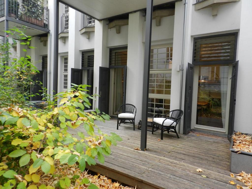 deux chaises sur une terrasse en bois devant un bâtiment dans l'établissement Art Deco Leipzig, à Leipzig