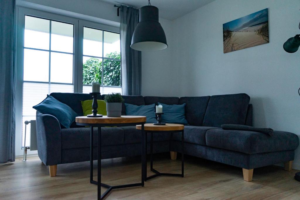 a living room with a blue couch and a table at Ferienwohnung Wassmann Hooksiel in Hooksiel