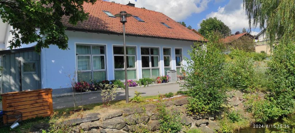a white house with a red roof at Ferienhaus am Bach in Achslach