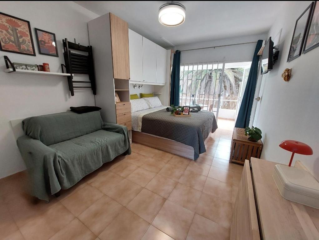 a bedroom with a bed and a couch in a room at Buenas Flores Tenerife in Costa Del Silencio
