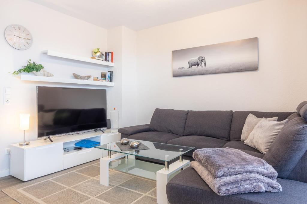 a living room with a couch and a tv at Ferienwohnung Ebbe in Hooksiel