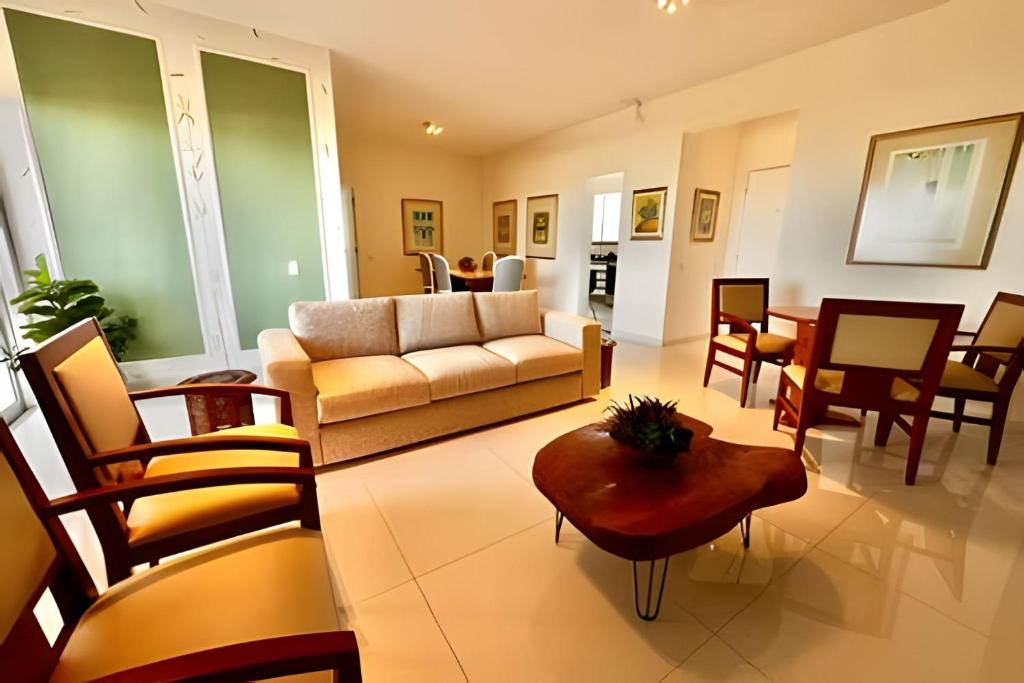 Una sala de estar con un sofá, una mesa y sillas. en Apartamentos e Suítes na Praia, en Fortaleza