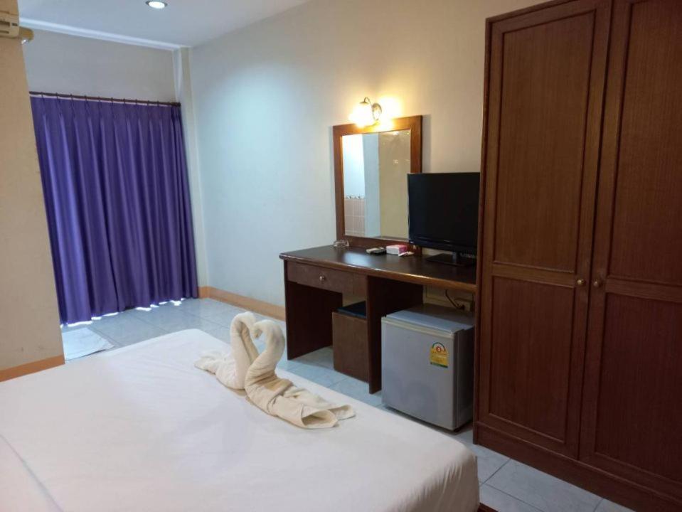 a bedroom with a bed with a desk and a mirror at ปะการังแมนชั่น in Udon Thani