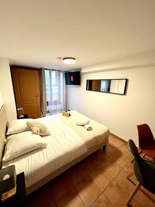 une chambre avec un grand lit et une chaise dans l'établissement Les chambres de la bastide - 203, à Carcassonne