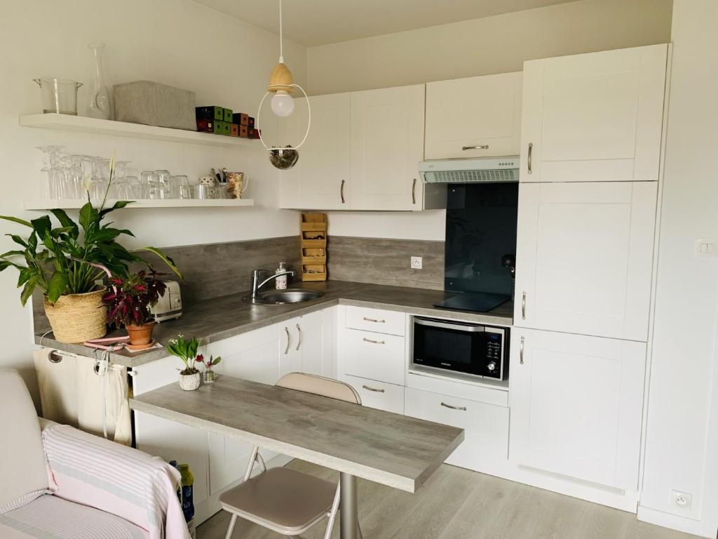 - une cuisine avec des placards blancs et une table avec un évier dans l'établissement Charmant T2 a 500 m du port avec parking privé, à Sanary-sur-Mer