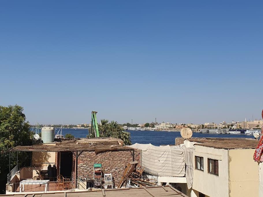 an old brick building next to a body of water at Sekhmet Appartement 2 chambres in Luxor