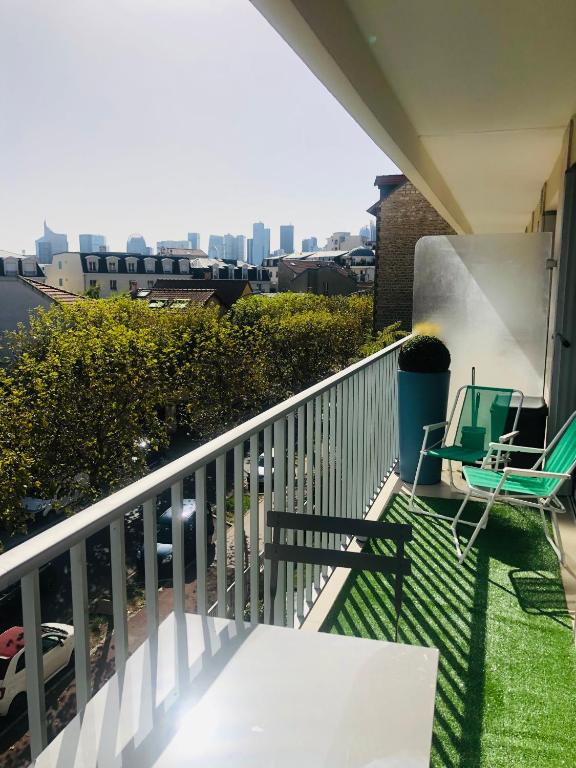 d'un balcon avec deux chaises et une vue sur la ville. dans l'établissement Appartement luxueux avec balcon à La Défense, à La Garenne-Colombes