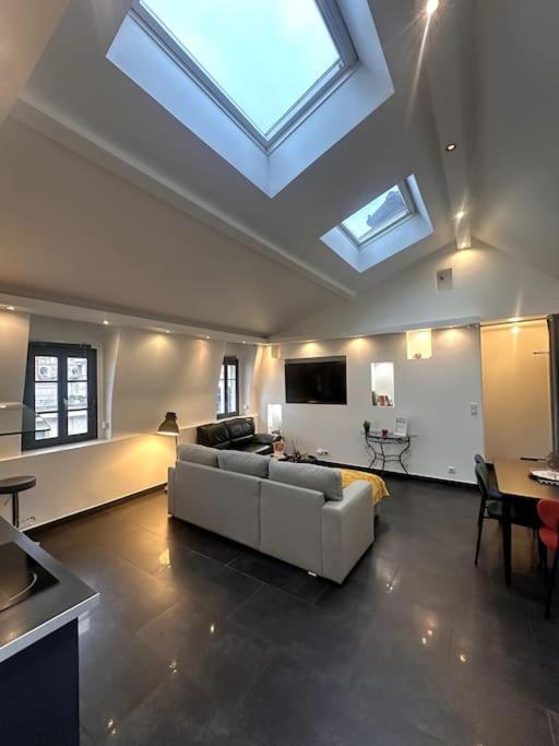 a living room with a white couch and a skylight at La Parenthèse- Place Martroi- Vue- Clim réversible in Orléans