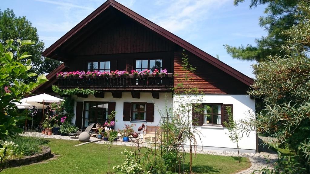 ein Haus mit einem Balkon mit Blumen darauf in der Unterkunft Apartment HAUS MERLIN am Böckelsberg in Weimar