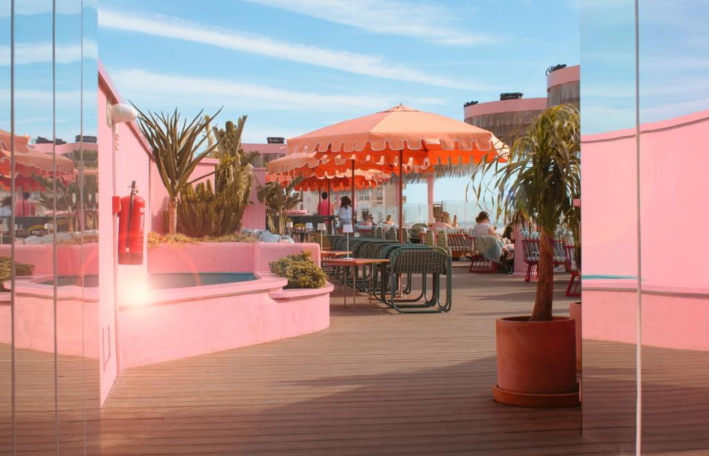 a patio with tables and chairs and an umbrella at Cádiz Bahía by QHotels in Cádiz