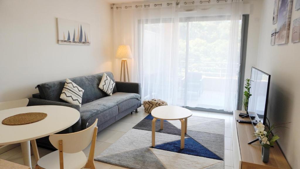 un salon avec un canapé et une table dans l'établissement T2, parking, balcon, Mer & Plages By Palmazur, à Théoule-sur-Mer