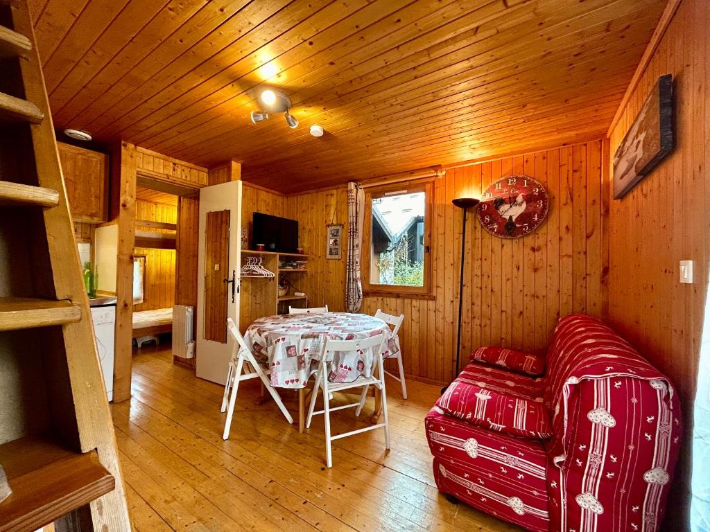 a dining room with a table and a couch in a room at Chalet Douillet - Jardin - Parking in Barcelonnette
