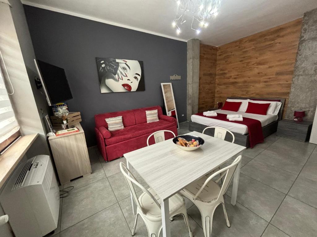 a room with a table and a bed and a couch at HappyHome Appartamento 4 posti letto Rivarolo Canavese in Rivarolo Canavese