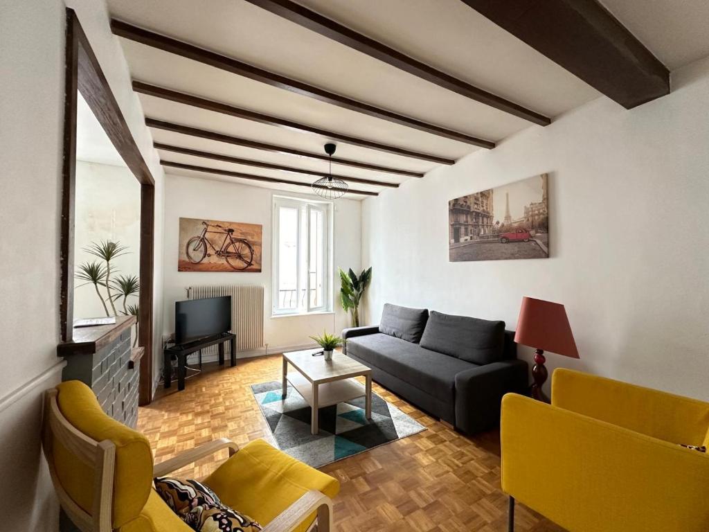 un salon avec un canapé et une télévision dans l'établissement Détroit - Maison spacieuse et lumineuse pour 8 personnes, à Reims