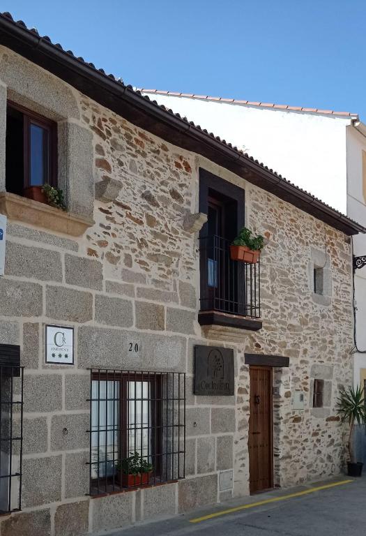 a stone building with plants on the windows at Ceclavinn Casa Rural in Ceclavín