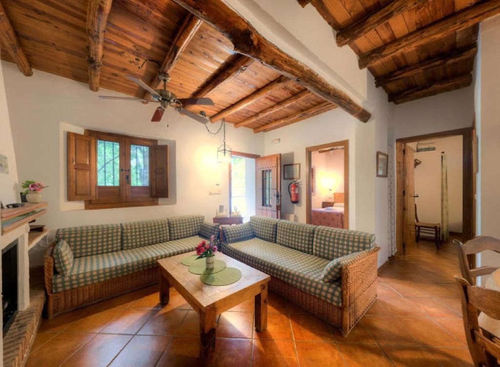 Sala de estar con sofás y mesa de centro en Cortijo Balzain, en La Zubia