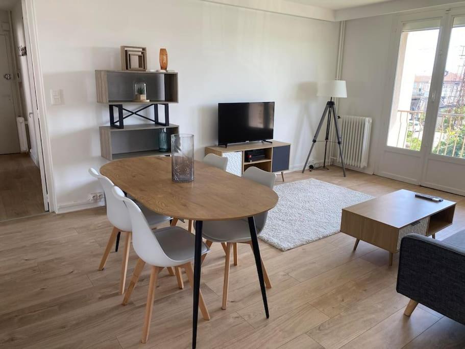 un salon avec une table et des chaises en bois dans l'établissement L'eskale, à Valence