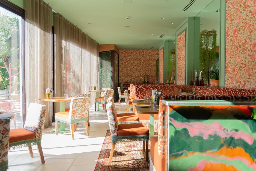 a restaurant with chairs and tables and a mirror at Hôtel Juana in Juan-les-Pins