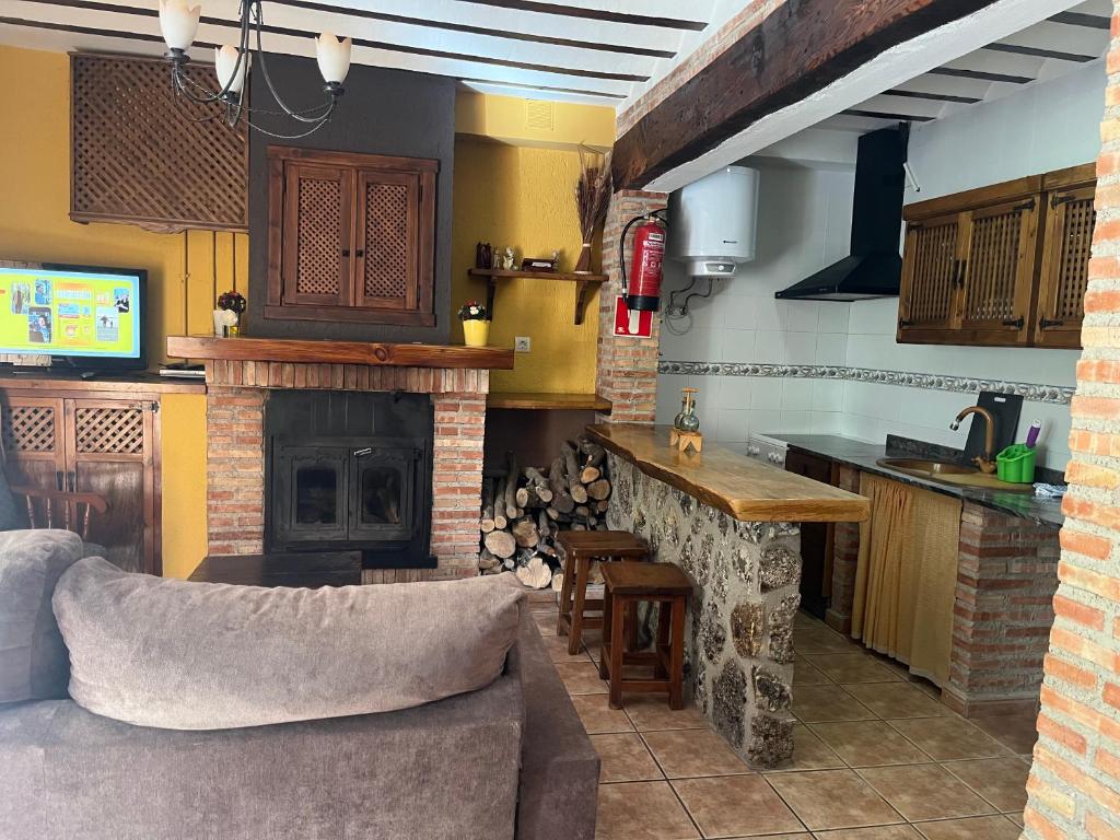 cocina con sala de estar con chimenea en Casas Rurales Arcoiris, en Riópar