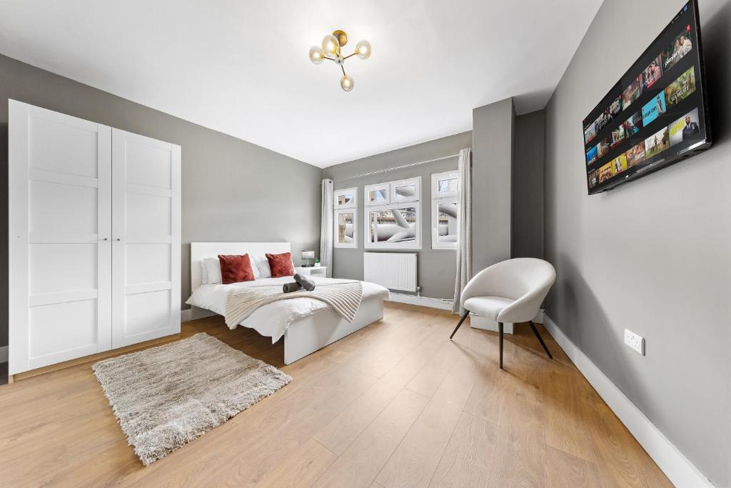 a bedroom with a white bed and a white chair at London Bridge Apartments in London
