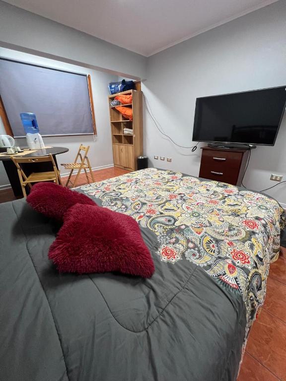 a bedroom with a large bed with red pillows on it at Casa Cavancha in Iquique