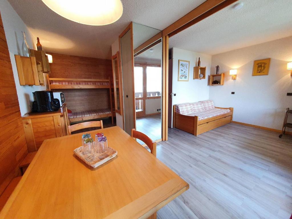 une chambre avec une table en bois et un salon dans l'établissement Studio divisible 4 pers. - Balcon, Animaux admis, Pied des pistes, Proches commerces - FR-1-353-74, à La Plagne