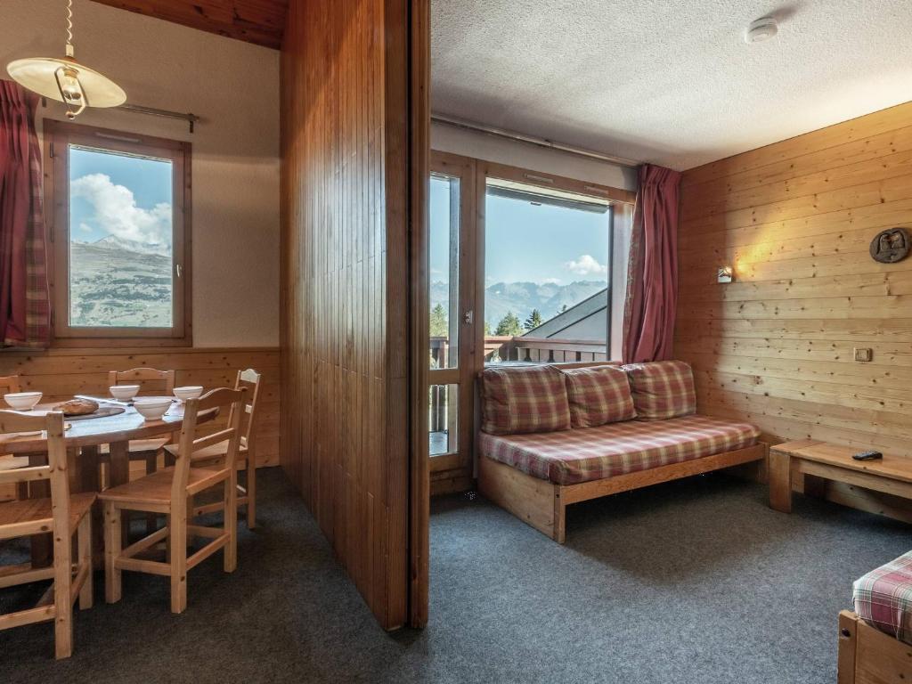Cette chambre comprend une table, un canapé et une fenêtre. dans l'établissement Duplex cosy pour 6 à La Plagne, au pied des pistes - FR-1-353-8, à La Plagne