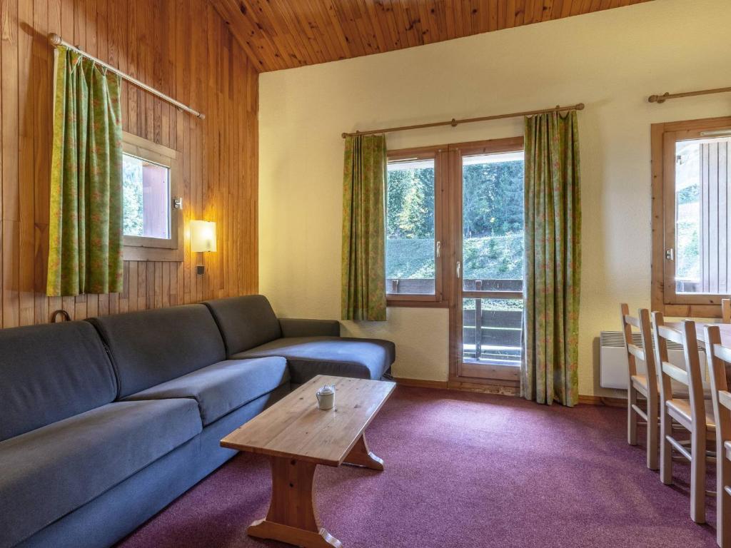 un salon avec un canapé bleu et une table dans l'établissement Duplex cosy 2 chambres, balcon, proche commerces et remontées, accepte animaux - FR-1-356-362, à Valmorel
