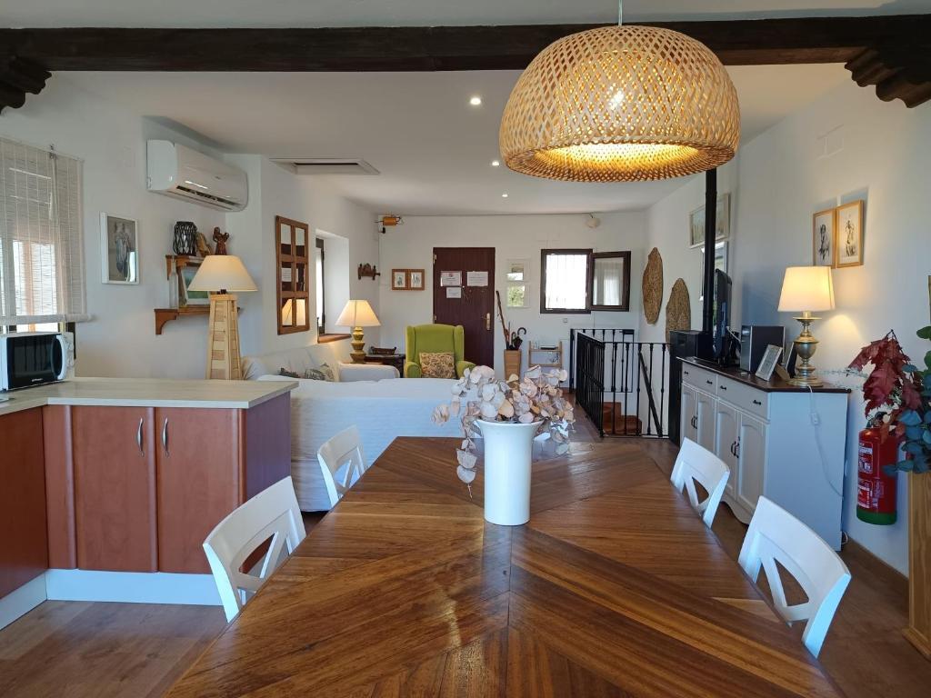a kitchen and living room with a wooden table and chairs at Casa Rural El Olivo in Aracena