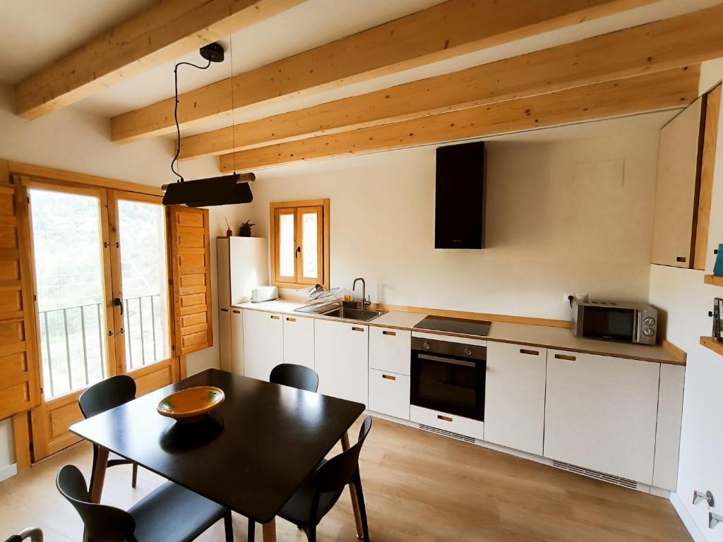 a kitchen with a table and a dining room at Cara Norte , Casa Rural-Castillo de Villamalefa in Castillo de Villamalefa