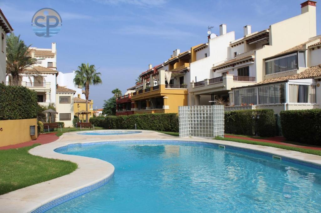 a swimming pool in front of some apartment buildings at Apartamento Costa de la Luz Golf y Playa in Ayamonte