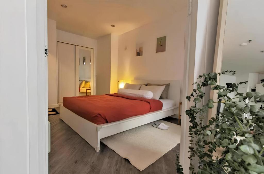 a bedroom with a bed with a red blanket at Cozy 1br walk to BTS and Airport Rail Link Close to Malls 11 in Bangkok