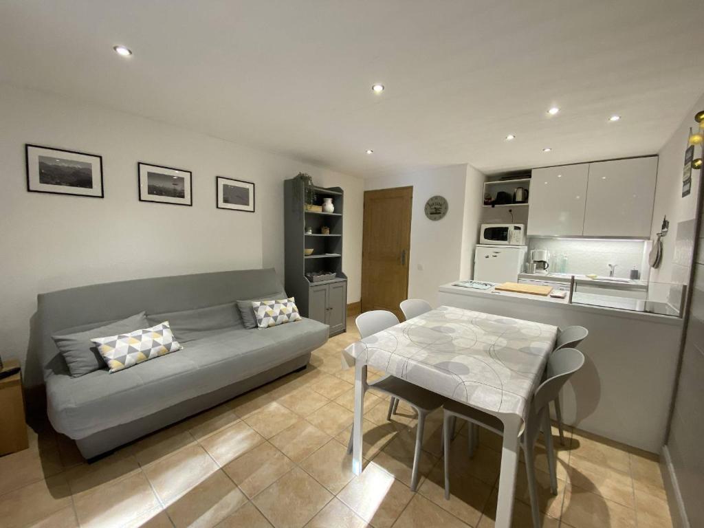 un salon avec un canapé et une table dans l'établissement Appartement cosy 3 pièces, avec balcon et piscine, proche des pistes et commodités à La Plagne Tarentaise - FR-1-353-118, à La Plagne Tarentaise