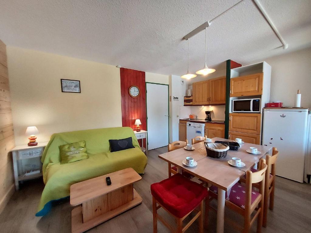 salon z zieloną kanapą i stołem w obiekcie Appartement cosy 3 pièces avec 2 balcons, lave-vaisselle, lave-linge, à proximité des pistes - FR-1-353-126 w mieście La Plagne Tarentaise