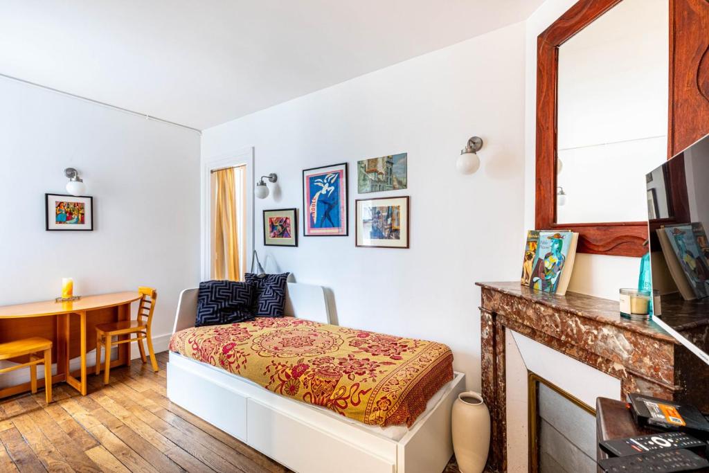 un salon avec un lit et une table dans l'établissement GuestReady - Espace Chic et Pratique pour 2, à Paris