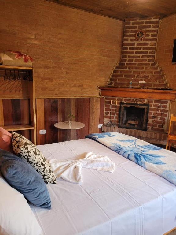 Chalés das cerejeiras في سانتو أنطونيو دو بينهال: شخص يستلقي على سرير في غرفة بها موقد